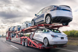 A car carrier truck carrying several cars on the road.