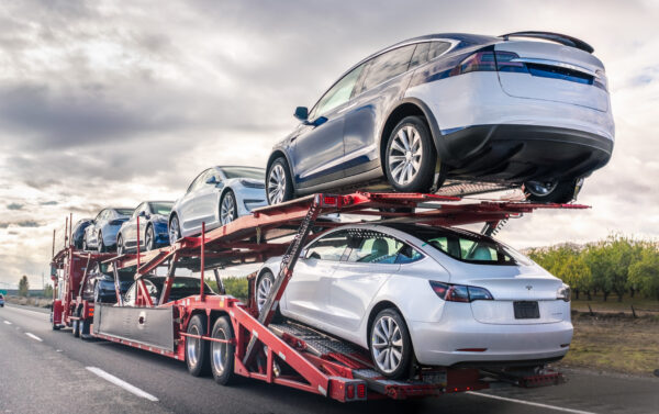 A car carrier truck carrying several cars on the road.