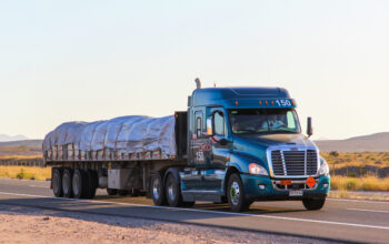 A semi truck is driving down the road.