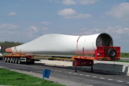 A large white truck on the road near grass.