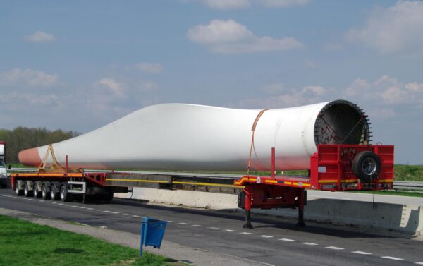 A large white truck on the road near grass.