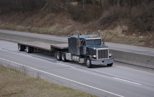 A semi truck is driving down the road.