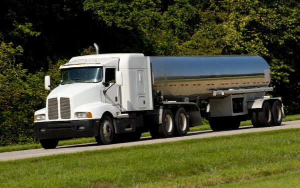 A white truck is driving down the road